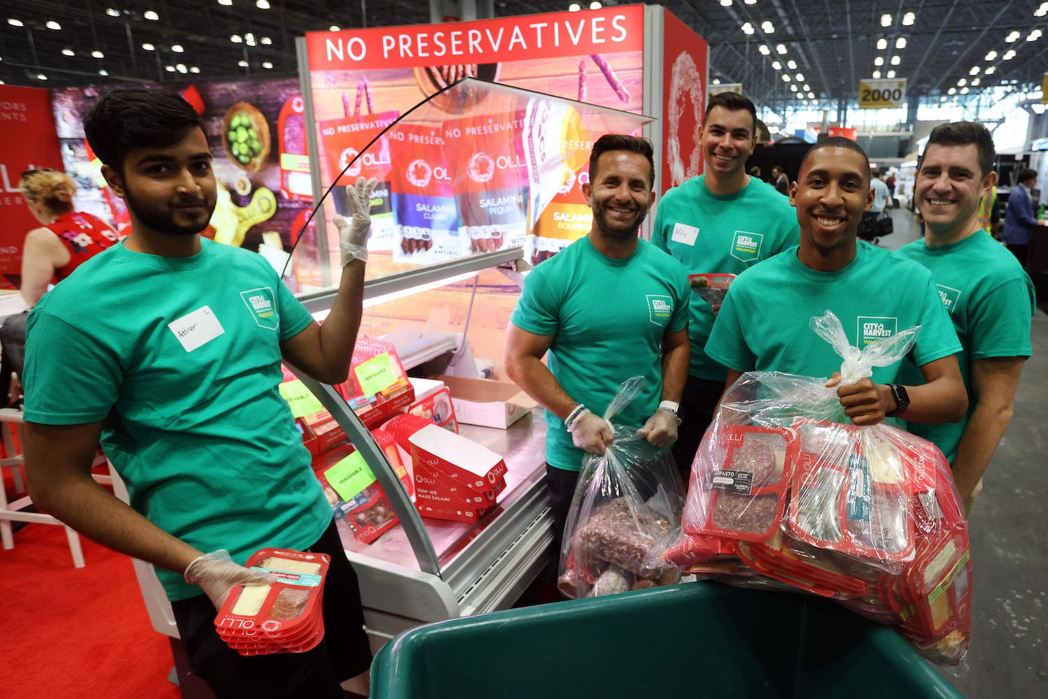 City Harvest Volunteers collecting up unused food after the Fancy Food Show - A group of smiling men with a cart and bags