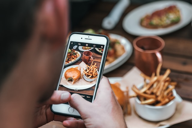 Person taking a picture of food with their smartphone camera.