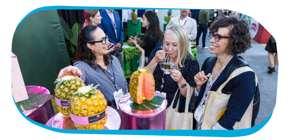 attendees gathered around food at exhibit booth